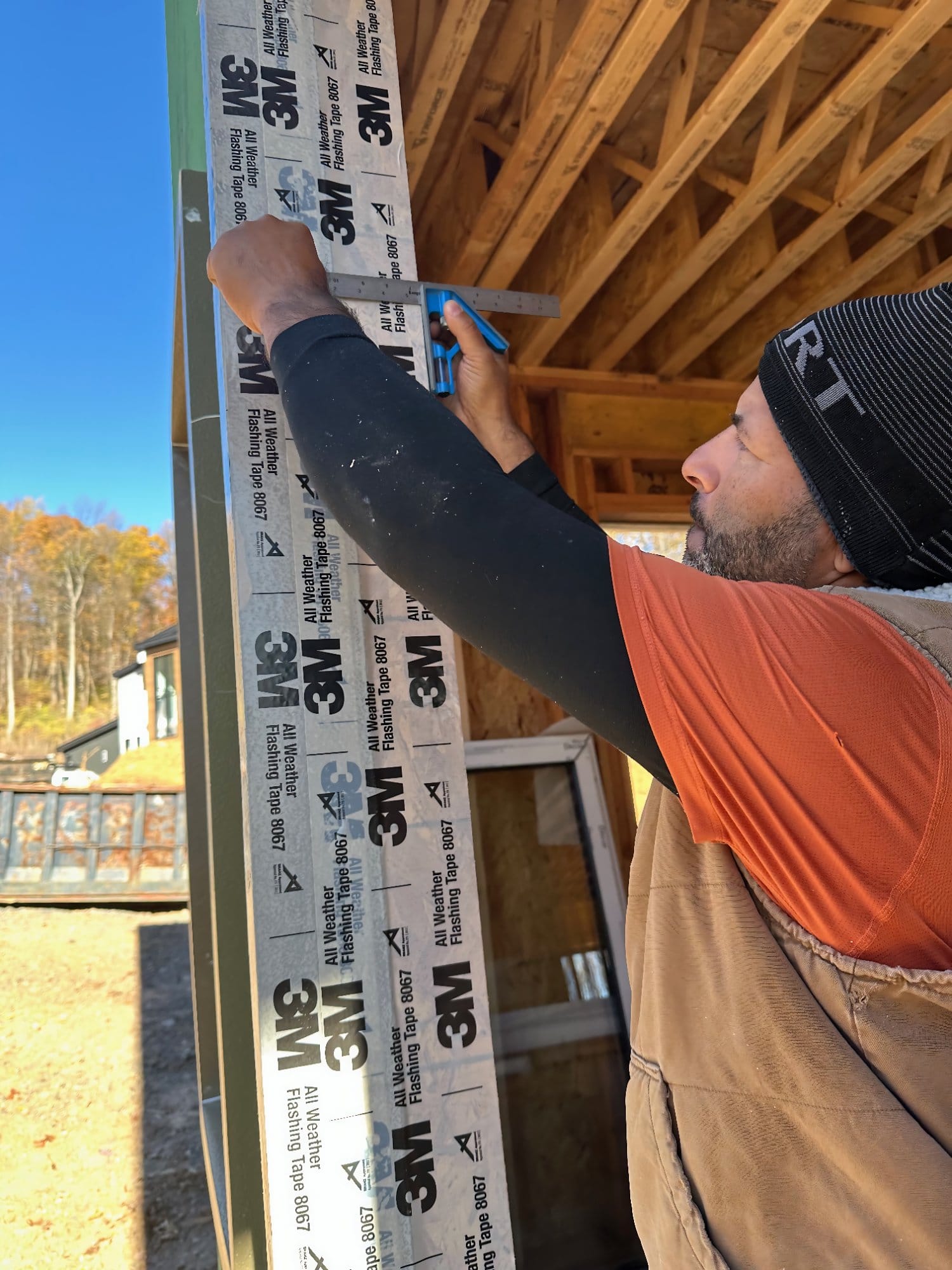 Builder installing window flashing by hand during construction