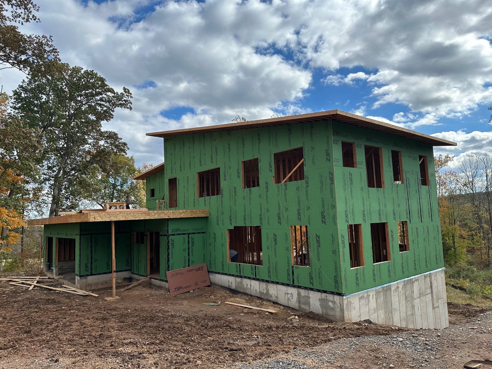 Home under construction wrapped in green ZIP System sheathing, every seam taped