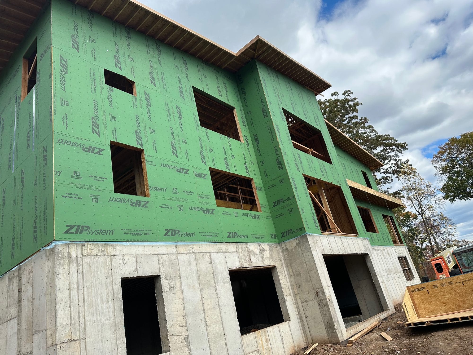 ZIP-sheathed walls rising from the poured concrete foundation of a home under construction